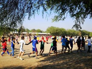 A group of people are playing frisbee in the sand.