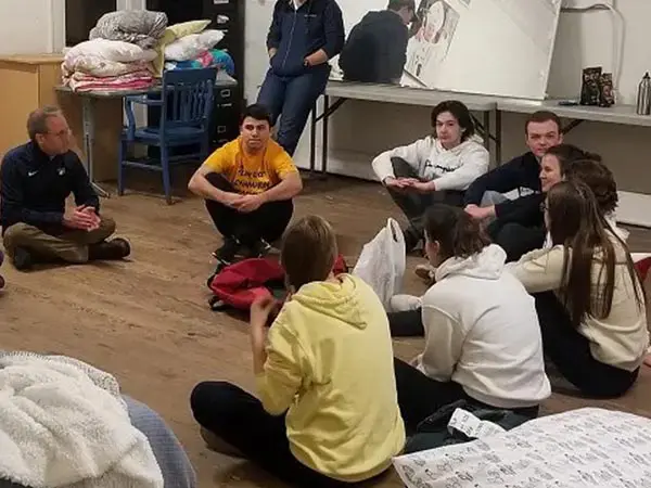 People sitting on the floor and talking to each other