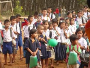 A group of children standing in the dirt.