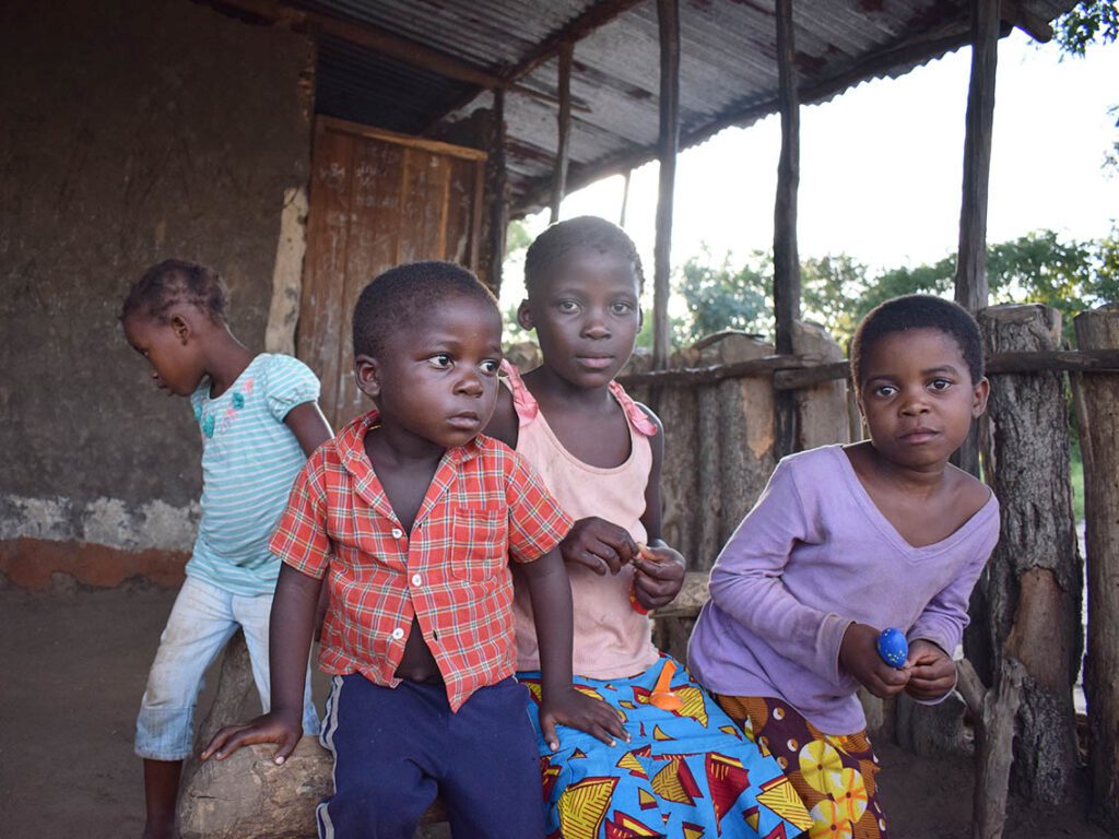 A group of children standing in front of a house.