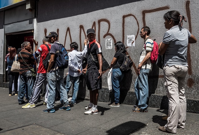 A group of people standing on the side of a building.