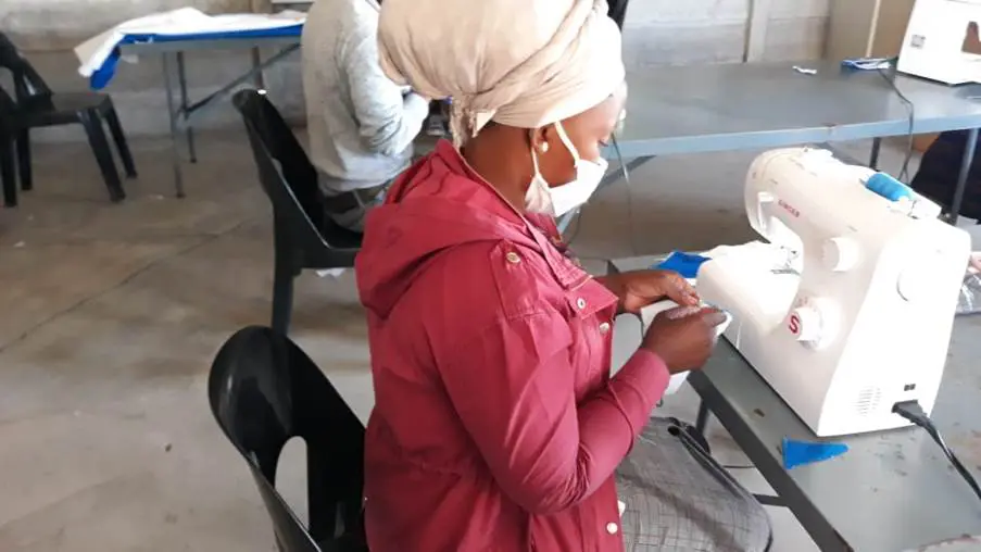 A woman wearing a head covering and holding something.