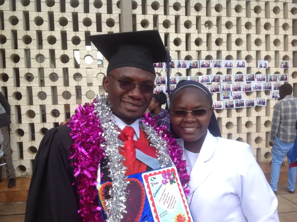 Two graduates smiling at a graduation ceremony.