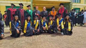 Graduates and faculty posing in academic regalia.