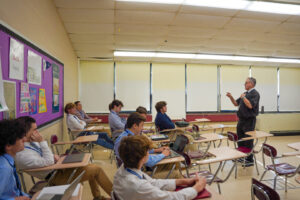 Teacher lecturing high school students in class.